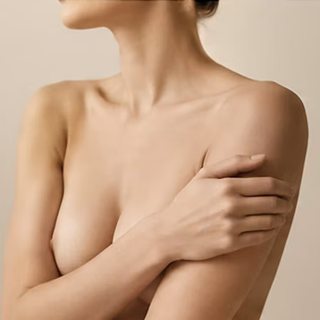 Le cou, l’épaule et le décolleté d’une femme, bras croisés sur la poitrine